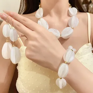 Elegant white marbled acrylic jewelry set featuring necklace, bracelet, and drop earrings.