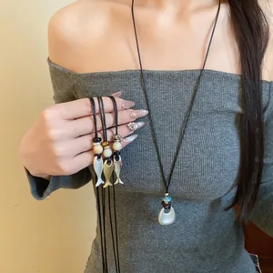 Collana retrò in pelle con pendenti a pesce in ceramica e un elegante charm in argento