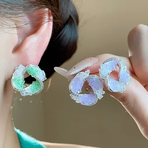 Close-up of zircon glass vortex earrings showing intricate sparkling textures and colors