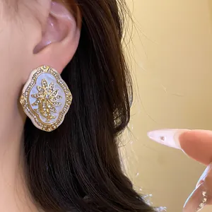 Macro view of vintage floral stud earrings with sparkling rhinestones and gold-tone finish