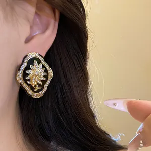 Macro shot of a vintage palace style flower stud earring with sparkling rhinestones on ear.