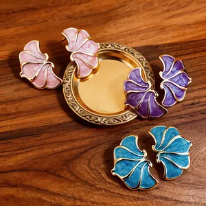 Macro detail view of elegant fan-shaped enamel stud earrings in pink, purple, and blue colors