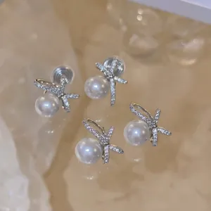 Detail showing exquisite pearl bow earrings with sparkling micro-pave crystals