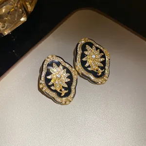 Macro view of vintage gold-tone floral earrings with S925 silver pins and pavé rhinestones
