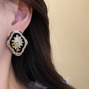 Close-up detail of vintage palace style floral stud earring with rhinestones worn on ear