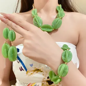Close-up of green marbled acrylic beaded necklace and matching jewelry set on model