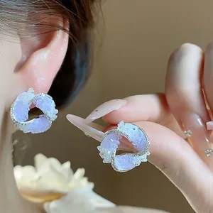 Close-up of elegant lavender swirl stud earrings with zircon-studded silver frame