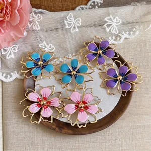 Eleganti orecchini a fiore cavo con petali in smalto colorato in blu, viola e rosa