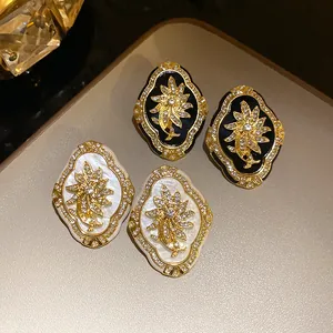 Vintage palace style gold plated flower earrings featuring sparkling rhinestones and enamel
