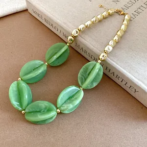 Elegant close-up of chunky green marbled acrylic beads and gold-tone beads necklace