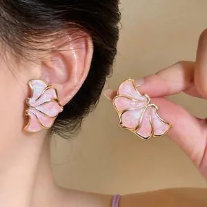 Detailed macro view of elegant pink enamel flower stud earrings with gold trim