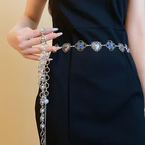 Detail of silver waist chain with pearls, stars, and blue stones on black dress.