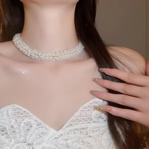 Close-up of an elegant French style woven pearl choker necklace worn by a model.