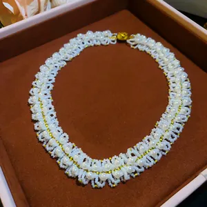 Detailed macro view of a vintage-style hand-woven pearl necklace with gold bead accents.