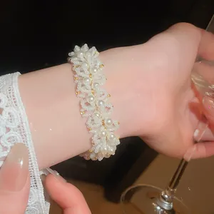 Close-up of elegant French retro pearl beaded bracelet worn on wrist for party vibes.