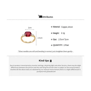 Detailed view of a vintage gold-plated ring with a large red square zircon and side stones.