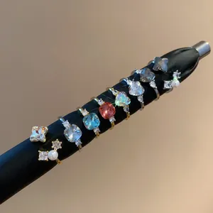 Close-up of vintage-style geometric zirconia and pearl open rings on a display rod