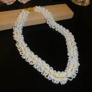 Detailed view of a French retro court style necklace with woven pearls and gold beads.