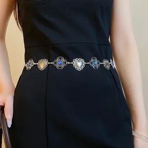 Vintage silver waist chain with heart filigree and blue stone accents on a black dress