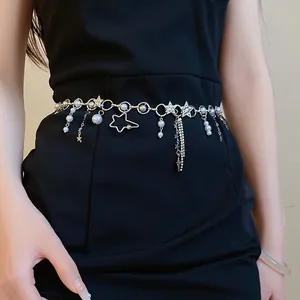 Close-up of elegant pearl star waist chain with rhinestone tassels on black dress