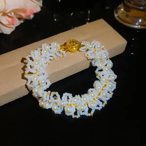 Detailed close-up of a French vintage pearl bracelet with a golden embossed clasp
