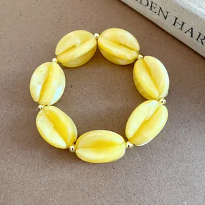 Macro detail of yellow marbled acrylic beads jewelry item with golden spacer beads