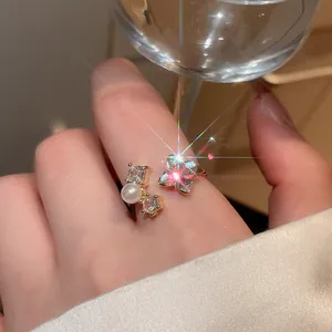 Close-up view of a vintage open ring featuring sparkling zircons and a delicate pearl.