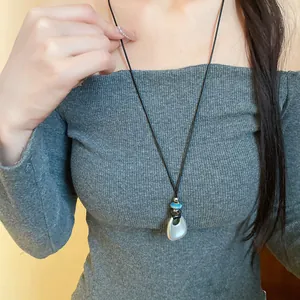 Vista dettagliata di una collana vintage con ciondolo a pesce in ceramica su cordino nero