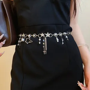 Detailed view of a star and pearl waist chain with rhinestone fringes on a black dress.