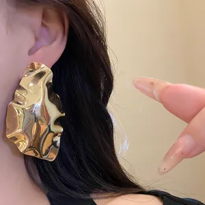 Large gold geometric pleated stud earrings for an elegant minimalist luxury look