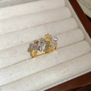 Detailed close-up of a vintage gold open ring featuring star-shaped zircon and a small pearl
