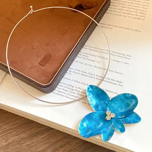 Vista dettagliata di una collana girocollo a fiore in smalto blu con strass