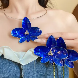 Dettaglio della collana girocollo con fiori di orchidea in smalto blu e strass lucidi