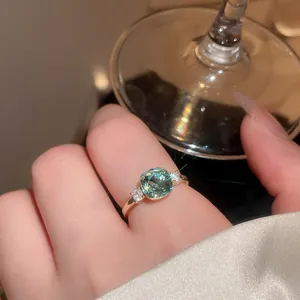 Close-up of vintage geometric gold ring with a sparkling cushion-cut green zircon stone.
