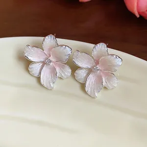 Nahaufnahme von eleganten rosa Emaille-Blumenohrsteckern mit funkelndem Zirkonia-Zentrum