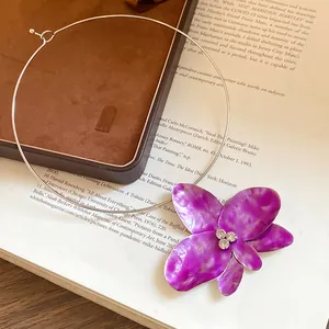Dettaglio del girocollo con fiore viola vintage e strass su sottile filo d'argento
