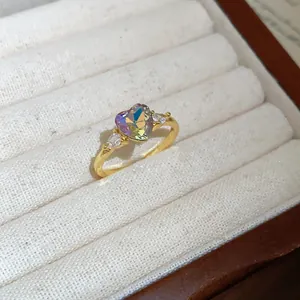 Macro view of a gold ring band with a colorful heart-shaped crystal and side zircons