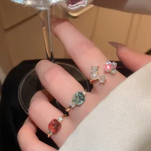 Detailed view of vintage zircon and pearl open rings on hand with sparkling accents