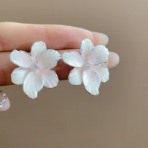 Nahaufnahme von rosa Blumenohrsteckern mit glitzernder Emaille und zentralem Zirkonia