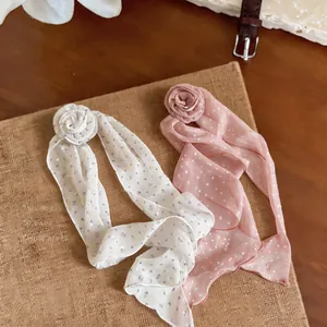 Detailed macro view of chiffon polka dot streamers with delicate floral rosette accents