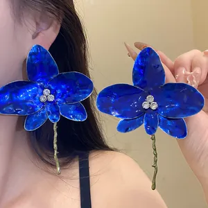 Primo piano di orecchini a orchidea blu con strass e finitura in smalto lucido