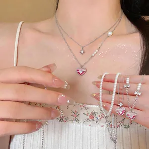 Detailed view of sweet Korean style pink enamel heart necklaces with pearls and zircons.