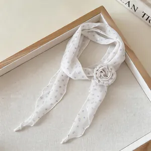 Detailed view of the white floral narrow neck scarf with a large fabric rose accessory