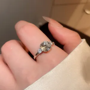 Close-up detail of cushion-cut zircon ring on finger with elegant light luxury style