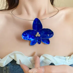 Dettaglio di un choker con orchidea blu vintage e strass luccicanti.