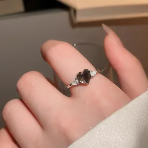 Close-up of a vintage-style silver ring with a dark heart-shaped zircon stone.