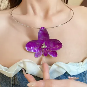 Primo piano dettagliato del girocollo con ciondolo a forma di fiore viola e strass