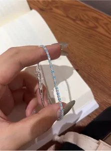 Detailed shot of an elegant silver bracelet featuring blue and white zircon stones