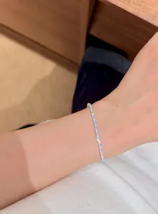 Elegant thin silver bracelet featuring light blue and white round zircons on an Asian wrist