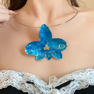 Dettaglio di un girocollo con ciondolo a fiore in smalto blu e strass vintage scintillanti